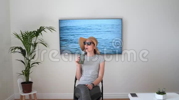 家里的女人假装在海滩上电视屏幕2020年夏季检疫旅行呆在家里视频的预览图