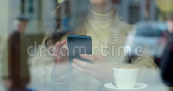漂亮的女人在咖啡馆的智能手机上使用应用程序在社交媒体上分享享受移动技术的信息视频的预览图