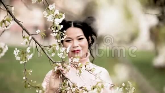 美丽的亚洲女人在春天的公共花园里捧花视频的预览图