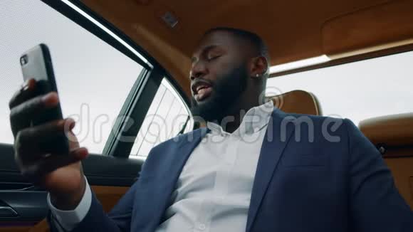 特写非洲男人在车上打视频电话商人在车上打电话视频的预览图