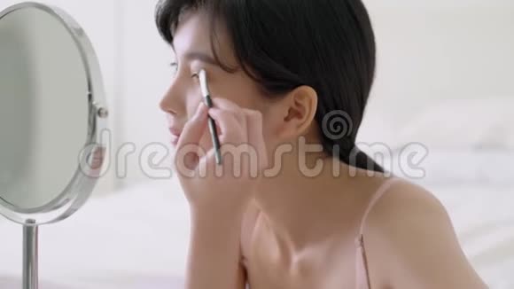 美丽的年轻亚洲女人化妆眉毛刷美丽的亚洲女孩化妆视频的预览图