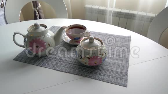 女孩把茶倒进桌子上的杯子里视频的预览图