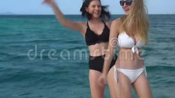 快乐美丽的两个年轻女子穿着性感的比基尼跳舞一起享受暑假在游艇游轮上的快乐视频的预览图