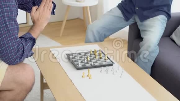幸福的家庭父亲和儿子一起下棋享受家里的沙发视频的预览图