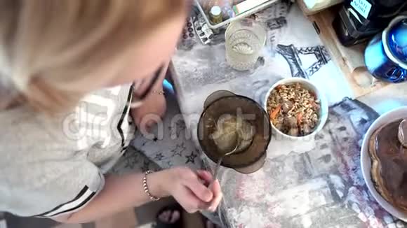 那个女孩坐在桌子旁吃汤上面的景色视频的预览图