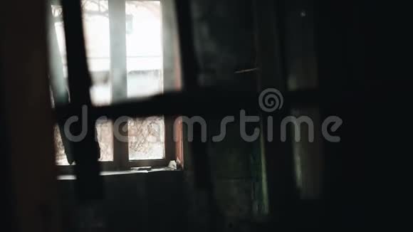 一个男孩穿过一座废弃建筑的房间它的轮廓反射在玻璃上视频的预览图
