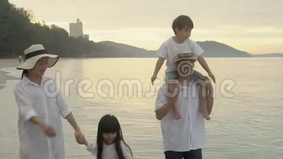 快乐亚洲家庭一起在海滩散步休闲度假父母和孩子快乐休闲热带风情视频的预览图