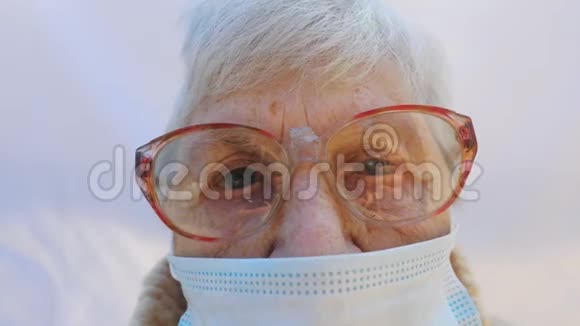 奶奶戴着防毒面具的肖像老太太看着镜头露出悲伤的情绪概念视频的预览图