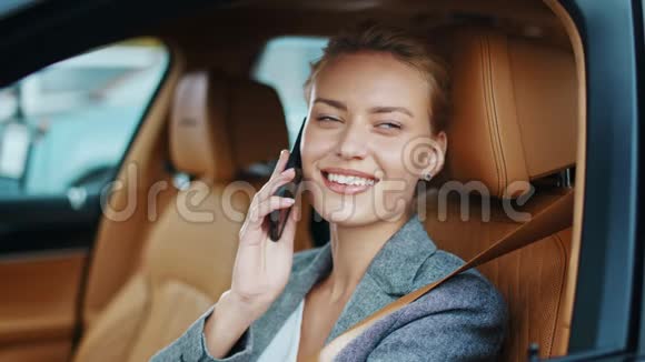 微笑的女商人坐在车里望着远方坐着时髦车服的女人视频的预览图