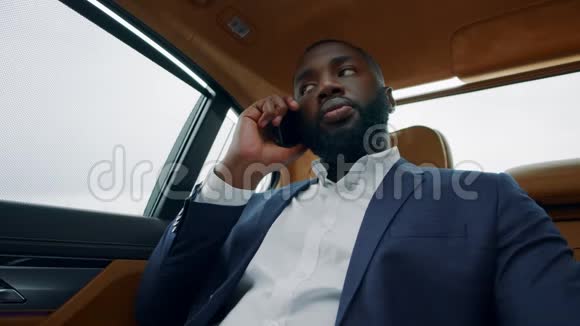 黑人商人在车里说手机非洲男人在车上打电话视频的预览图