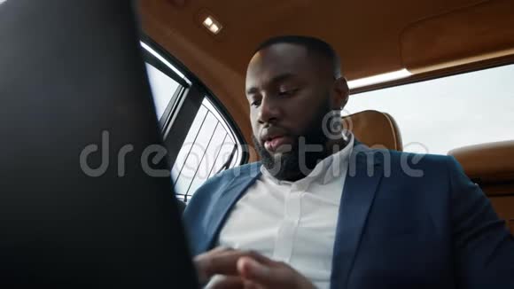 特写阿弗罗人在车上工作笔记本电脑商人在电脑上聊天视频的预览图