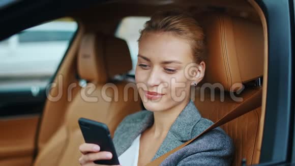 在车上用电话做特写女司机微笑着坐在前排视频的预览图