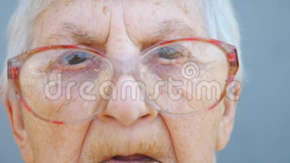 带有沉思视线的眼镜奶奶的详细肖像一张布满皱纹的女性养老金领取者的脸视频的预览图