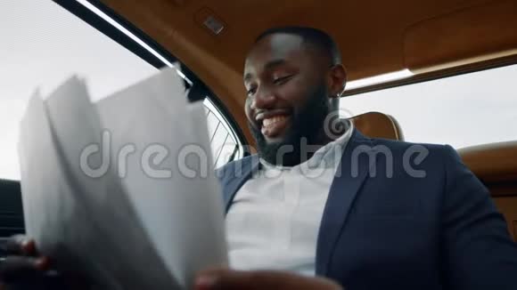 特写记者在车上看文件在后座享受成功的商人视频的预览图
