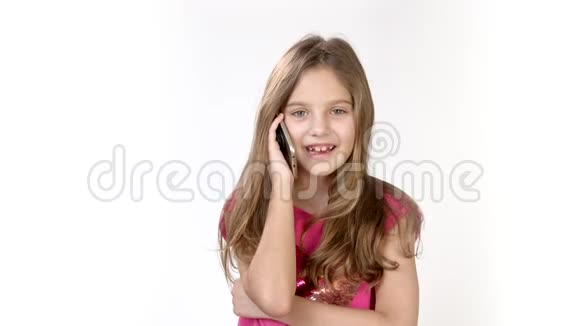 在一个小女孩的电话里情绪化的谈话一个小女孩穿着一件白色的亮粉色连衣裙在打电话视频的预览图