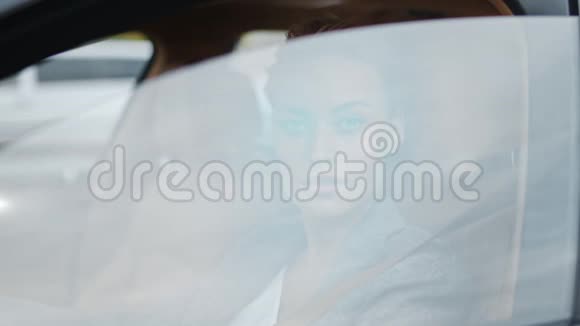 特写女人从车窗上滚下来坐在前排的女商人视频的预览图