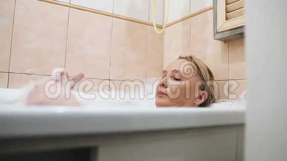 女孩躺在浴室里里面装满了水和泡沫视频的预览图