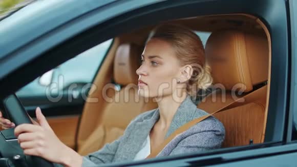贴身女商人坐在方向盘后面女人在车里跳舞视频的预览图