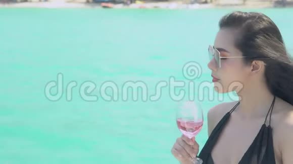 美丽的年轻亚洲女人喝着酒杯在海边度假享受游艇巡游视频的预览图