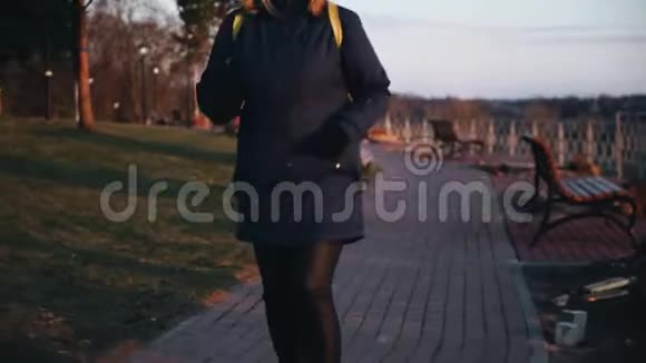 一个穿夹克的女孩晚上在公园跳舞好心情视频的预览图