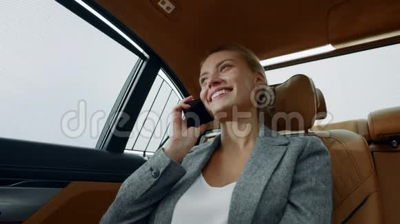 微笑的女人在出租车上打电话女商人在车上打电话视频的预览图