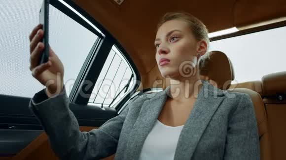 特写聚焦的行政女性在车上做视频聊天使用手机的妇女视频的预览图