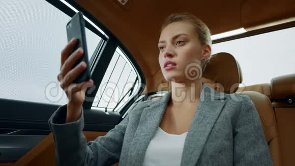 漂亮的女商人在车上打视频电话专注的女人摸脸视频的预览图
