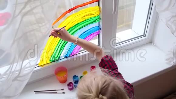 4k女孩在家里的Covid19隔离期间在窗户上画彩虹家庭社交媒体运动视频的预览图