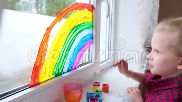 4k女孩在家里的Covid19隔离期间在窗户上画彩虹家庭社交媒体运动视频的预览图