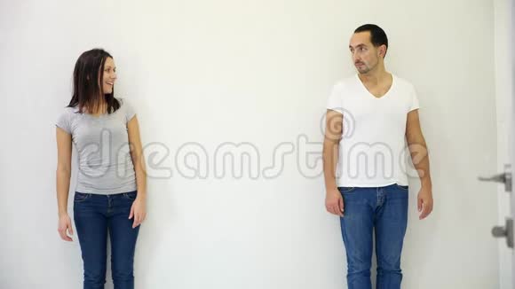 漂亮的男人和女人站在白色背景的不同侧面指向他们之间的共空间视频的预览图