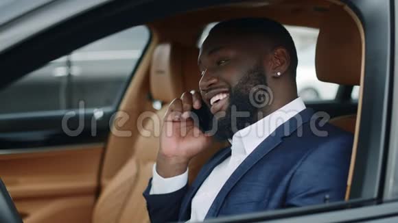 新车里的贴身商人在打电话坐豪华车的非洲男人视频的预览图