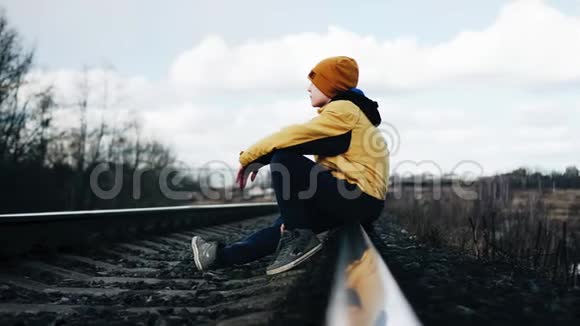 一个孤独的男孩坐在铁路上孤独的家伙困难儿童视频的预览图
