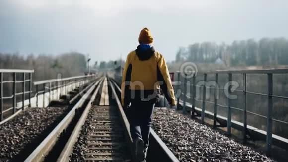 男孩跳上铁路桥的栏杆向远处望去视频的预览图