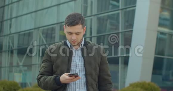 男人使用智能手机语音记录功能在线行走在城市街道上与移动助理交谈使用人类视频的预览图