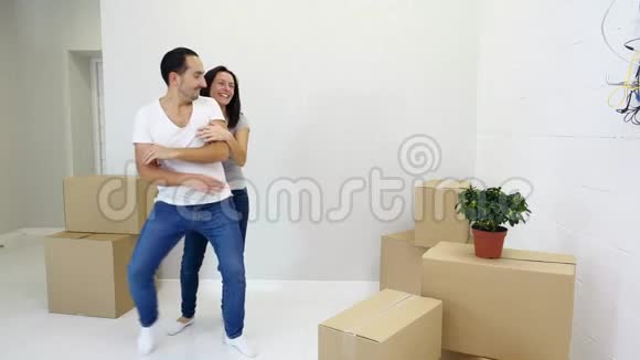 第一次买房的夫妇在客厅里和一堆盒子一起跳舞一起欢笑一起享受乐趣视频的预览图