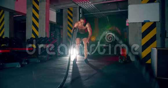 男子运动员在健身房练习战斗绳史诗般的光无摄像机运动摄像机内绳视频的预览图