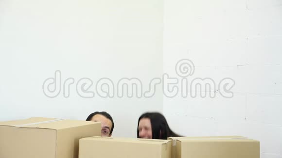 托西高加索夫妇从纸箱后面出现把他们新公寓的钥匙展示给相机视频的预览图