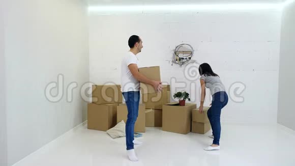 年轻夫妇从他们的旧公寓里打包和搬运纸板箱视频的预览图