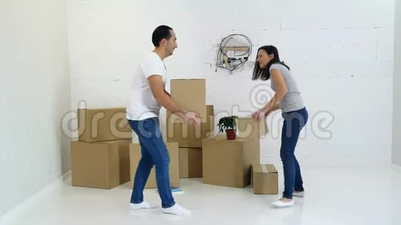 年轻夫妇从他们的旧公寓里打包和搬运纸板箱视频的预览图