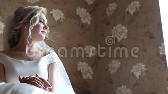 可爱的年轻新娘早上在家准备好了准备婚礼的新娘穿着一件视频的预览图