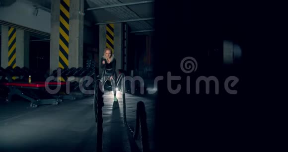 女孩运动员在健身房运动战绳史诗灯相机内绳视频的预览图