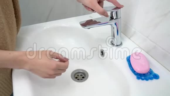 年轻女子用肥皂和水洗手的特写镜头视频的预览图