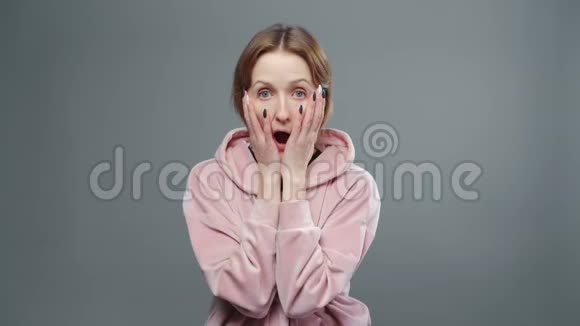 穿着粉红色运动衫的年轻惊讶女人视频的预览图