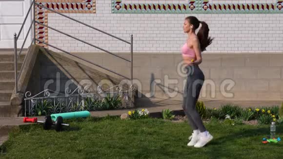 健身运动训练公园和生活方式的概念微笑的欧洲妇女在家户外跳绳运动视频的预览图