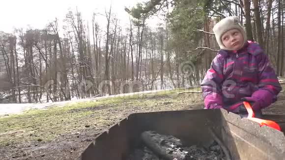 烤架和森林里的女孩春天雪树森林边缘视频的预览图