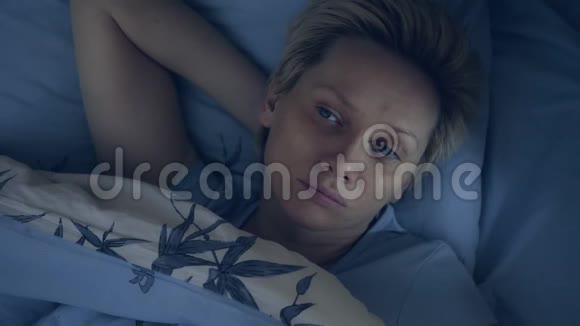 一个患有失眠症的女人躺在黑暗中眼睛睁着视频的预览图