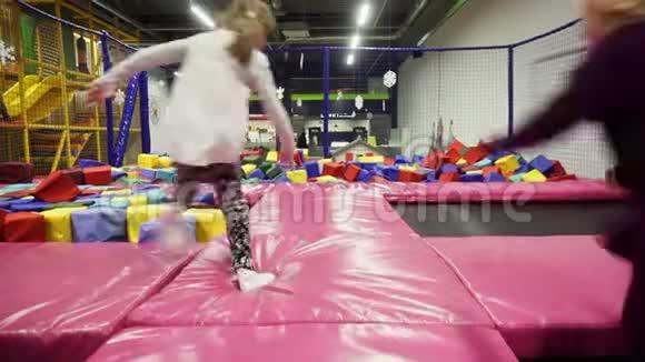 孩子们在室内蹦床上跳在当地游乐园蹦床上玩得很开心视频的预览图