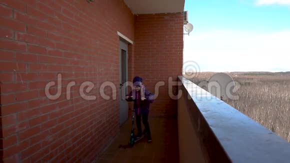 女孩骑着摩托车在公寓附近的阳台上回家视频的预览图