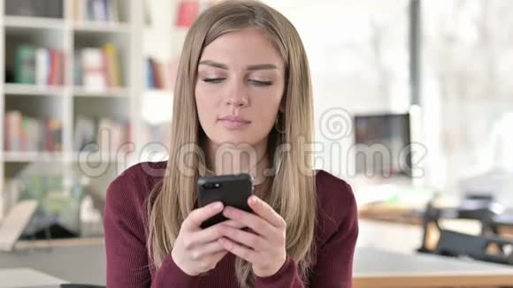 微笑的年轻女子在智能手机上交谈的照片视频的预览图