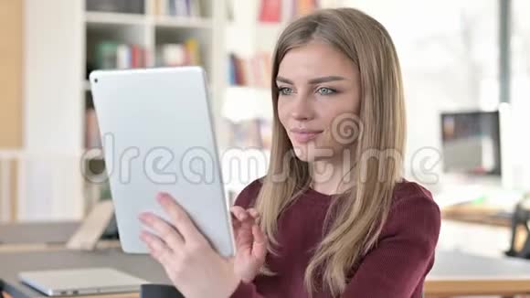 青年妇女在平板上的视频聊天画像视频的预览图